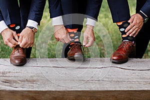 The men wears shoes with stylish socks. Stylish suitcase, men`s legs, multicolored socks and new shoes. Concept of style, fashion