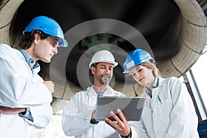 men and woman engineers using tablets for monitoring factory