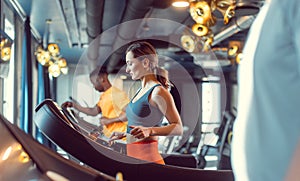 Men and woman in the gym running on treadmill