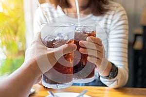 Men and Woman hand giving glass of cola.Glass of cola photo