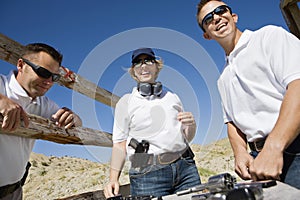 Men And Woman With Hand Guns At Firing Range