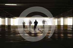 Men and woman playing soccer in parking lot. Conceptual image