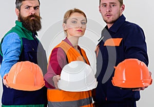 Men and woman wears uniform and holds helmets