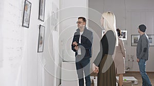 Men and women in an art gallery inspect the abstract works of contemporary artists. Visitors at the Museum of Modern Art