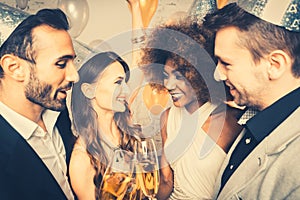 Men and women celebrating party while clinking glasses