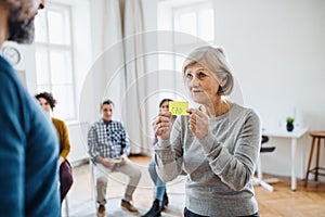 Men and women during group therapy, expressing negative emotions.