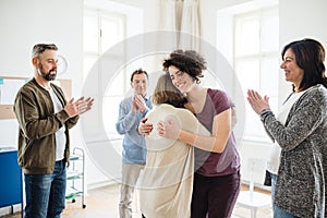 Men and women during group therapy, showing a sign of relief.