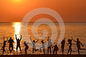 Men and women jumping and enjoying life at sunrise