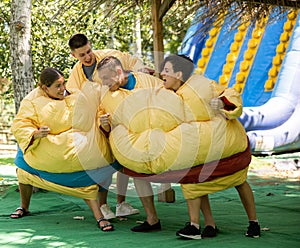 Men and women in large sumo suits having fun in adventure park