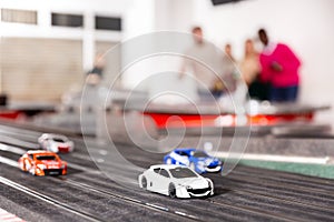 Men and women play with slot car racing track