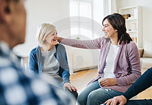 Men and women sitting in a circle during group therapy, supporting each other.