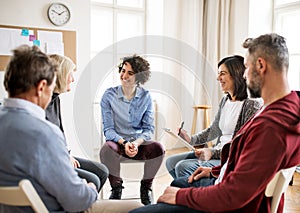 Muži ženy v kruh během skupina terapie mluvení 