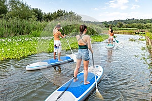 Men and women stand up paddleboarding