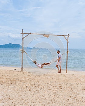 Men and women on a sunny day with a hammock on the beach in Pattaya Thailand Ban Amphur beach