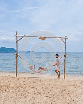 Men and women on a sunny day with a hammock on the beach in Pattaya Thailand Ban Amphur beach