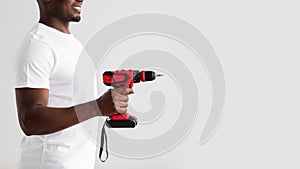 Men work, home renovation, construction or carpentry business. Black man holding electric drill, side view