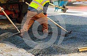 Men at work, urban road under construction, asphalting in progress