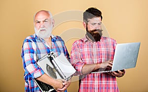 Men work writing devices. Old generation. Digital technologies. Senior man with typewriter and hipster with laptop