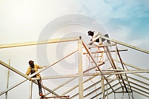 Men workers on steel roof construction structure industry with