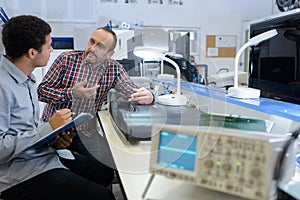 men working in electronics workshop