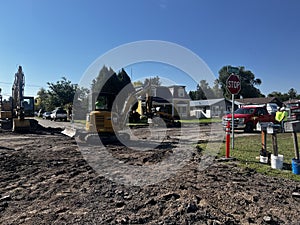 men working on road construction project with a mini excavator and large excavator