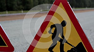 Men working road sign at the side of the road