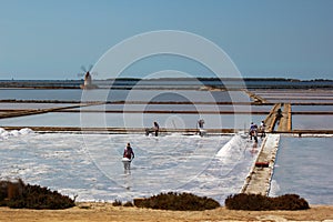 Men working on the saltpans in Mozia in Sicily photo