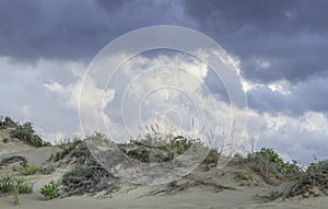 Menacing clouds over the pure white sandunes at Sampieri beach in Sicily in a summer windy day photo