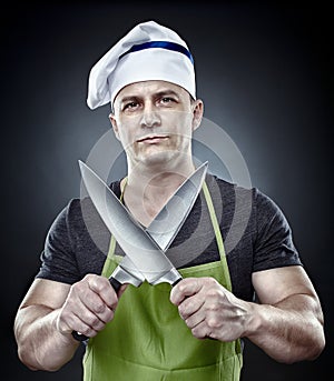 Menacing man cook holding two sharp knives