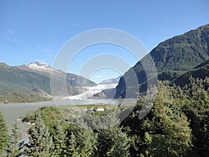 Mendenhall Glacier Juneau Alaska. Mendenhall Glacier flowing into Mendenhall Lake in between mountains with Nugget falls. Perfect