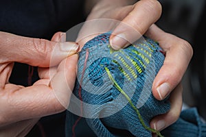 Mending clothes. Visible mending repairing sock