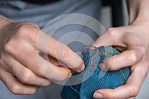 Mending clothes. Visible mending repairing sock