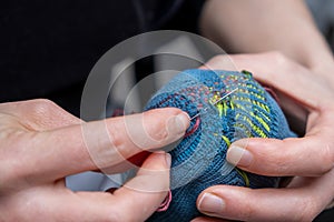 Mending clothes. Visible mending repairing sock