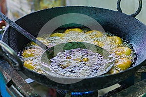 Mendu wada or medu Vada being deep fried in a kadhai i at roadside restaurant. Meduwada is a popular South Indian snack served