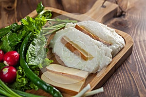 Mengrelian corn mamalica ghomi with cheese and various herb on wooden table. Georgian traditional food photo