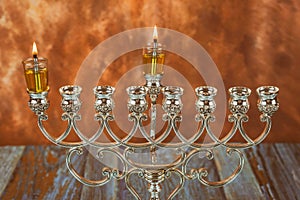 Menorah a traditional Jewish holiday lighting the first candle on a hanukkahof a burning Chanukah candles Menorah