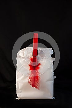Irregular period concept. Menstrual cycle pad with red feathers on black background. Menorrhagia or heavy menstruation photo