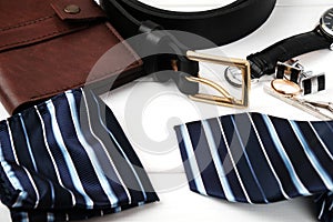 Mens accessories - wallet, belt, cufflinks, watch, handkerchief and ring on a white wooden background