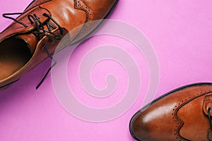 Mens brown shoes on a purple background with a copy of the space. Delivery and sale of shoes