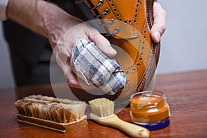 Mens Footwear Care Ideas. Closeup of Mans Hands with Cleaning Cloth