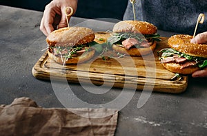 Mens hands holding hold wooden board burgers grilled meat