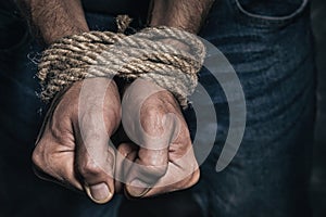 Mens hands tied with a rope. Concept of imprisonment in modern society photo