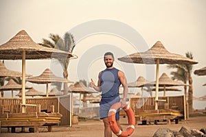 Mens heals body care. man with red life ring at beach