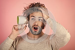 Mens heals care. surprised man with disheveled hair hold cup at ear, gossip