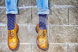 Mens Legs Wearing Brown Oxfords Semi Brogues Shoes. Posing Outdoors Against Stony Grunge Background