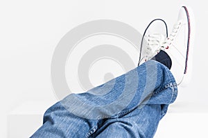 Mens Legs on White Fashion Sneakers and Jeans Laid on High Support