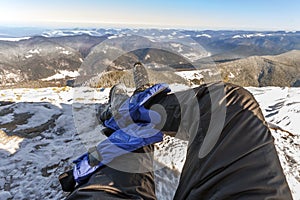 Mens legs in winter shoes against panorama over the Carpathian m