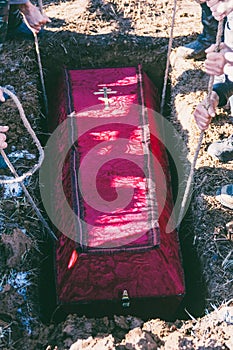 Mens lowered the coffin into the grave