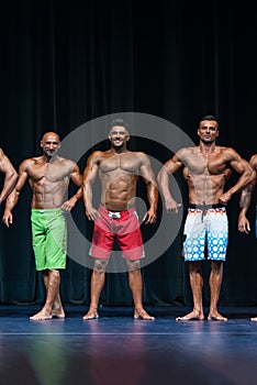 Mens Physique Posing During A Bodybuilding Competition