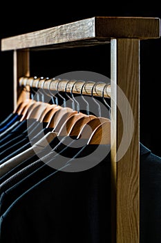 Mens shirts, suit hanging on rack. Hangers with jackets on them in boutique. Suits for men hanging on the rack. Mens